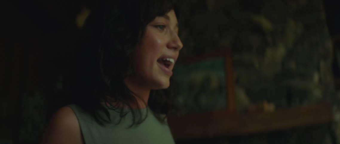 A woman is screaming at a man sitting on the couch