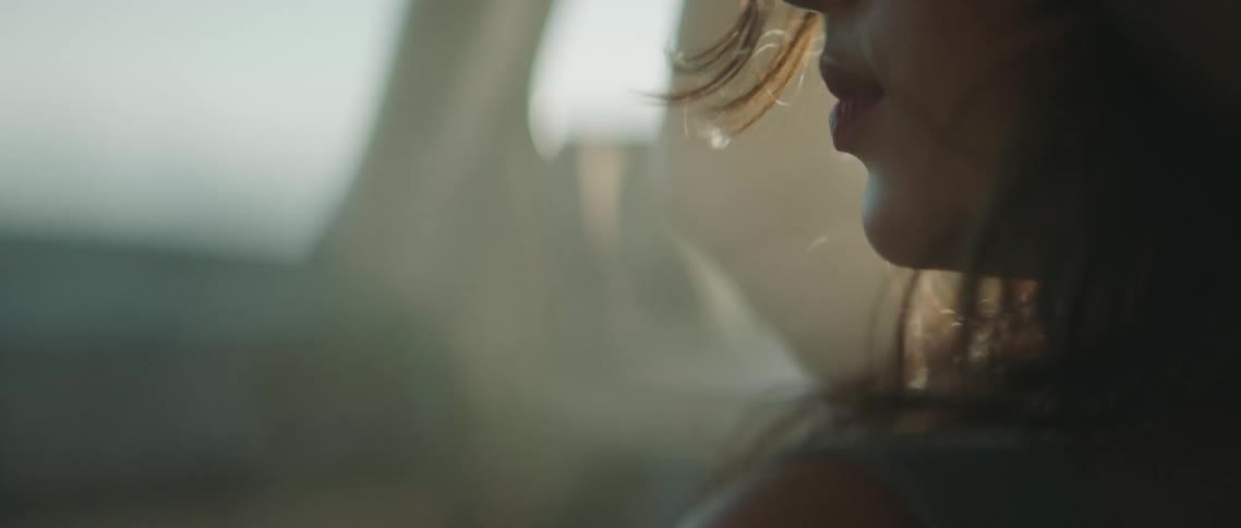 A woman in a vehicle with smoke with the sky and clouds in the background