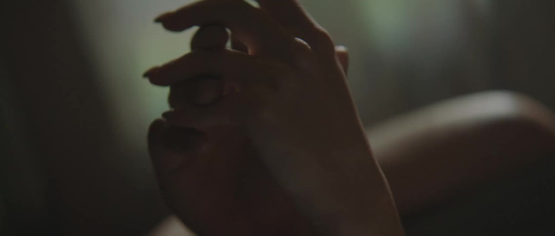 A couple hold hands in bed