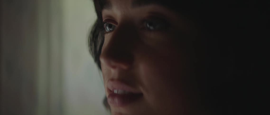 A teenage boy and girl stand in front of a mirror and look in to one anothers eyes
