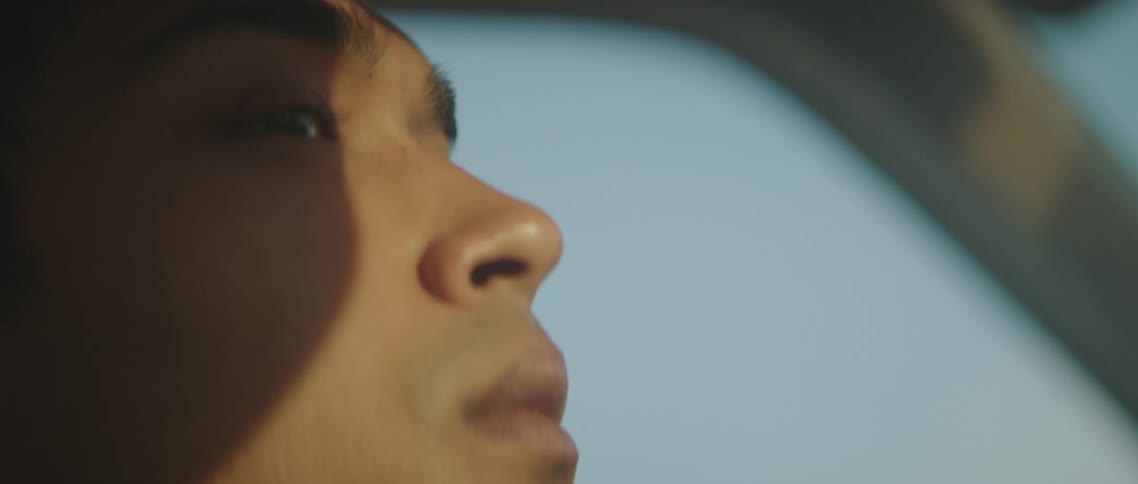 A man is riding in the vehicle on a sunny day