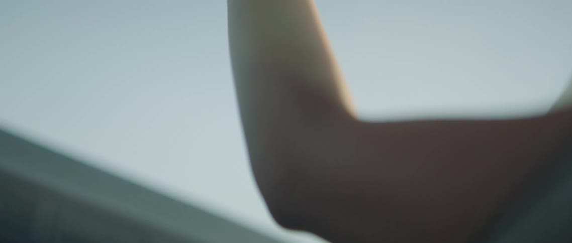 A person waves their arm around in the moving car