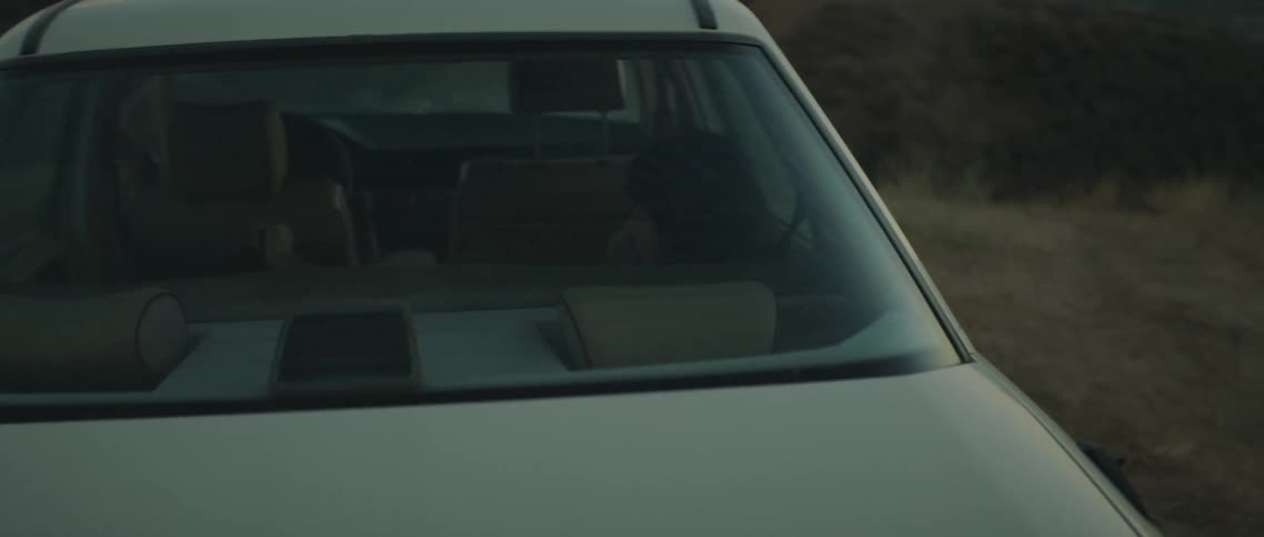 A woman is laying in the backseat of the car