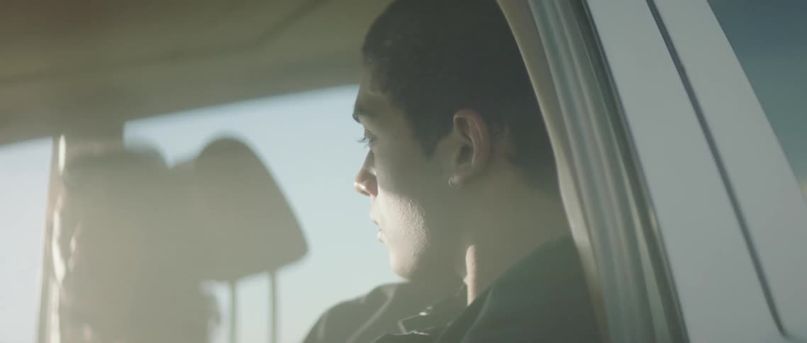 A man is looking at a woman as they travel in a vehicle