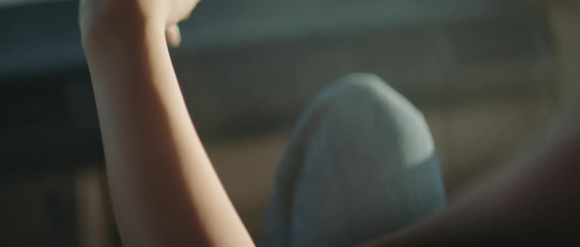 A person moves their arm around in the car