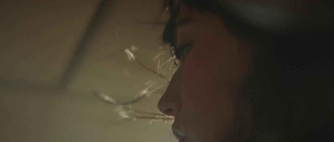 Close up of a woman with her hair blown by the wind and smoke inside a car