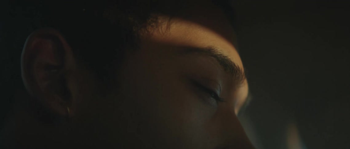 A man is looking at a distance as light passes through his face