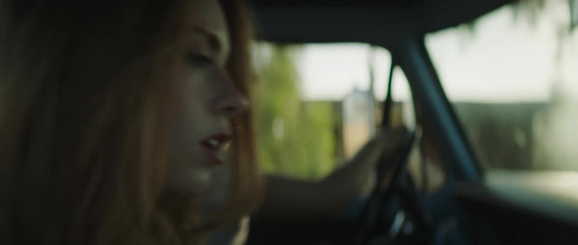 A woman leans over and kisses a man as he drives a truck