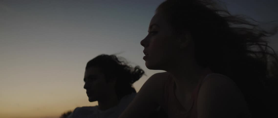 A couple ride in the back of a pickup truck