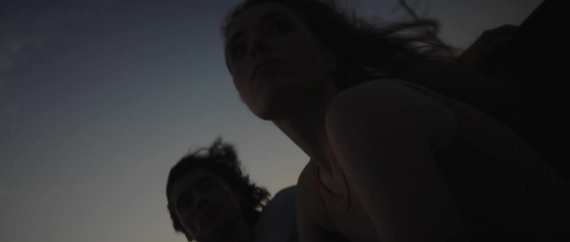 Two women sitting in the back of a car driving down a road