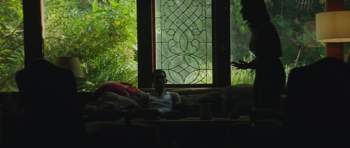 A woman paces back and forth as her partner sits on the couch