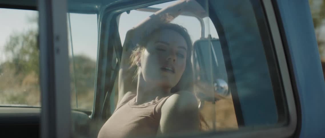 A woman is hanging out the truck window