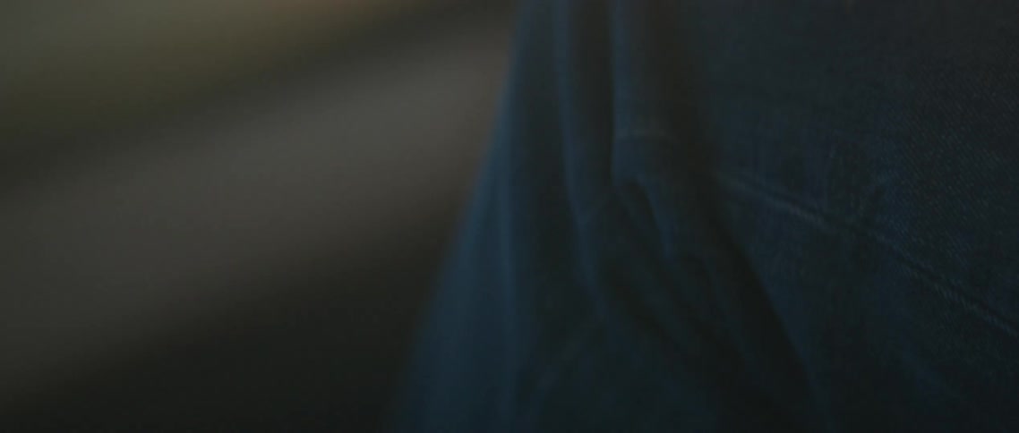 Sunlight over the waving hand of a young woman sitting on the passenger seat of a car