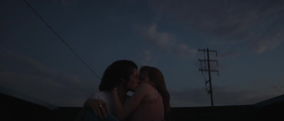 A couple are kissing in the back of the pickup truck