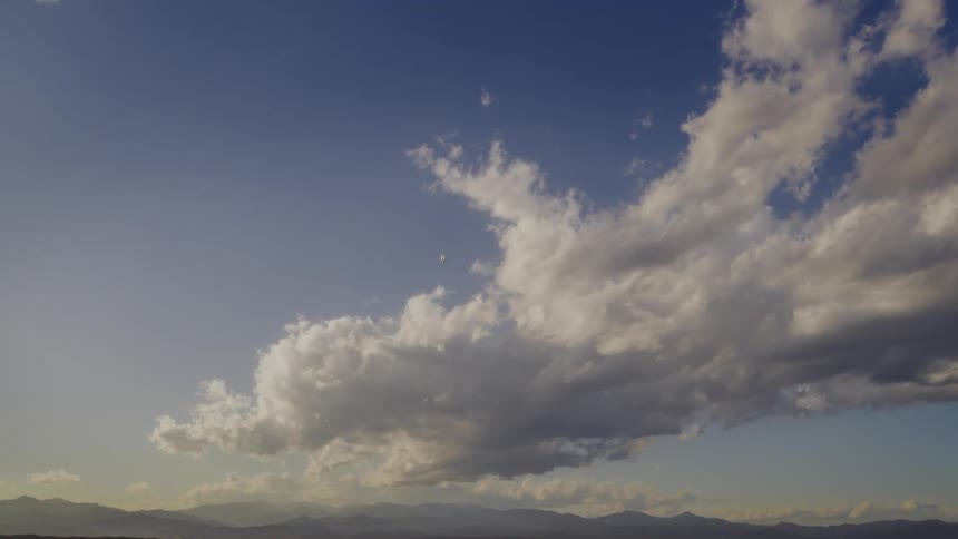 A vehicle drops from the clouds towards the mountain range