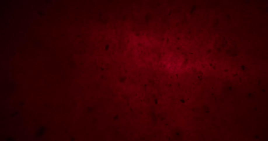 Black pieces of debris float down in a red background