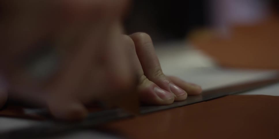 A person uses a razor to cut something