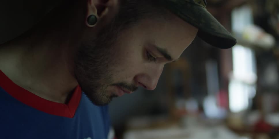 A man in a blue shirt works in a workshop