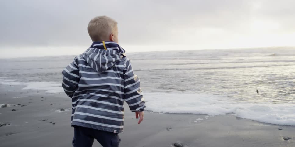 A boy throws a rock into the water