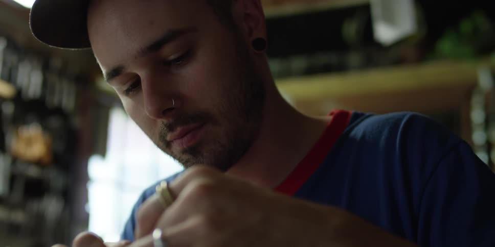 A man is working in a shop tying something