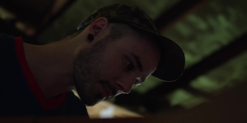 A man concentrates on something he is working on just below camera view