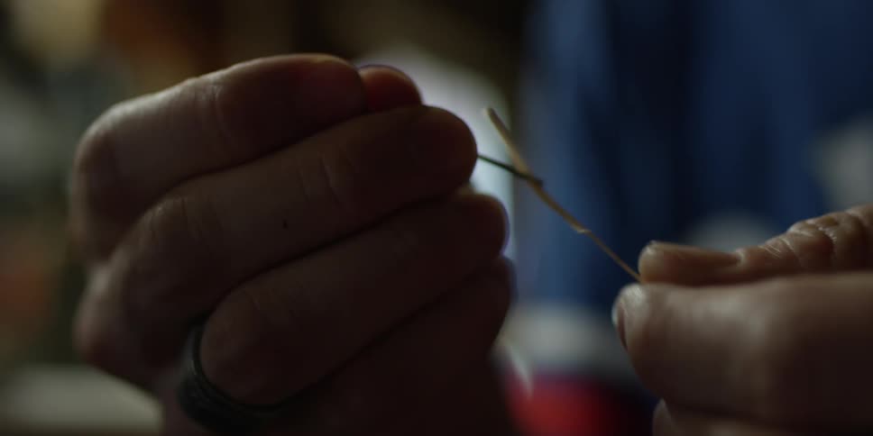 A person is threading a needle