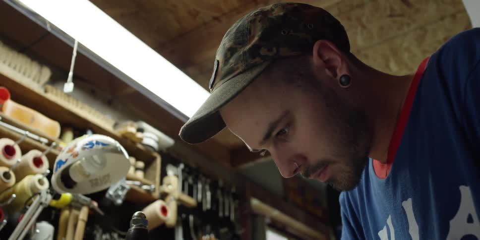 A man in a workshop concentrates on his work