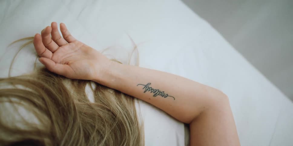 Woman lies with arm stretched over her head