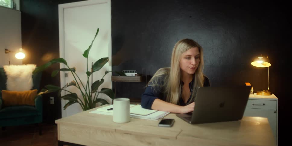 A woman sits down at her desk