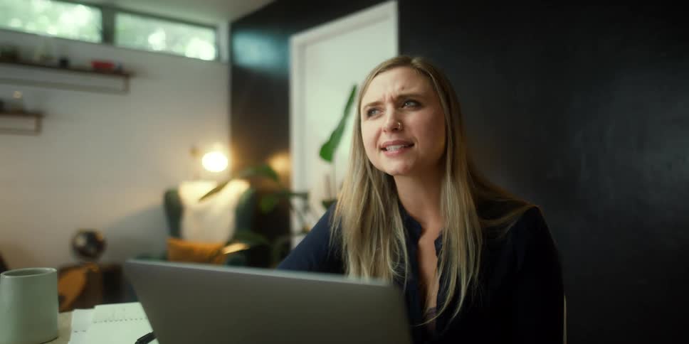 A woman speaks animatedly during a video call on her laptop