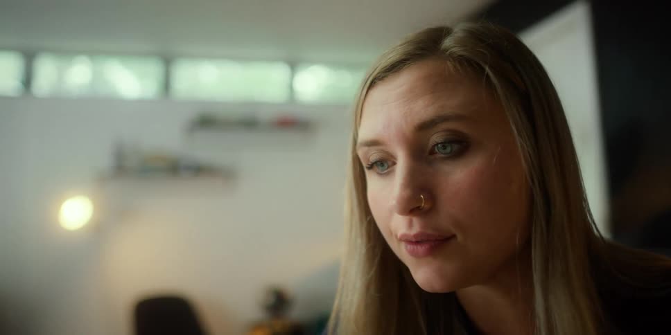 A woman speaks while sitting indoors during the day