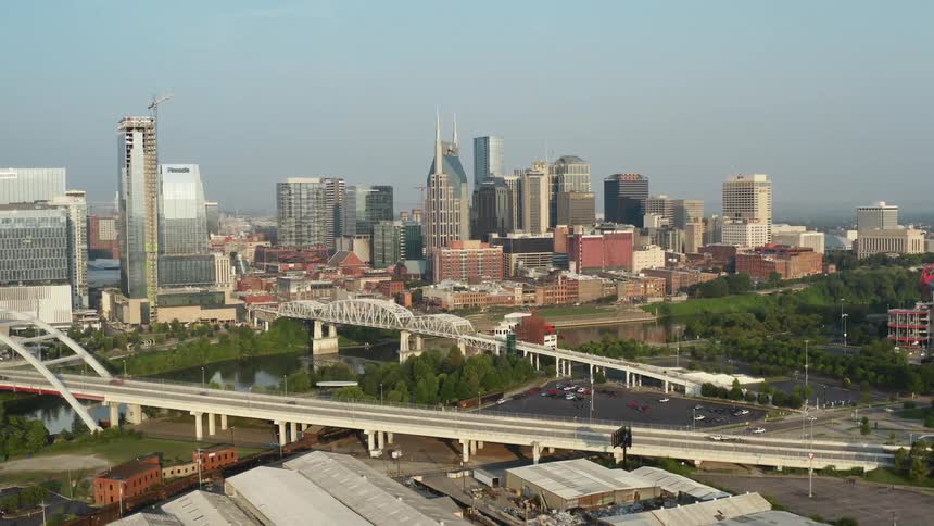 Aerial view of high rise buildings and vehicles crossing white bridges