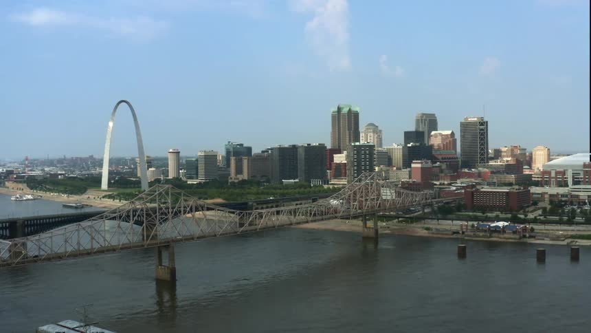 Traffic travels on a bridge over the river near the city