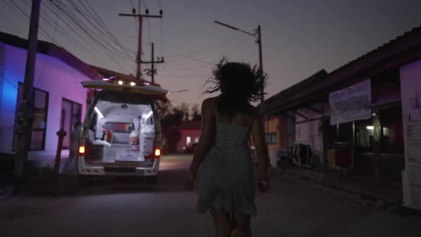 Woman with short dress runs down the street with lights passing by white van