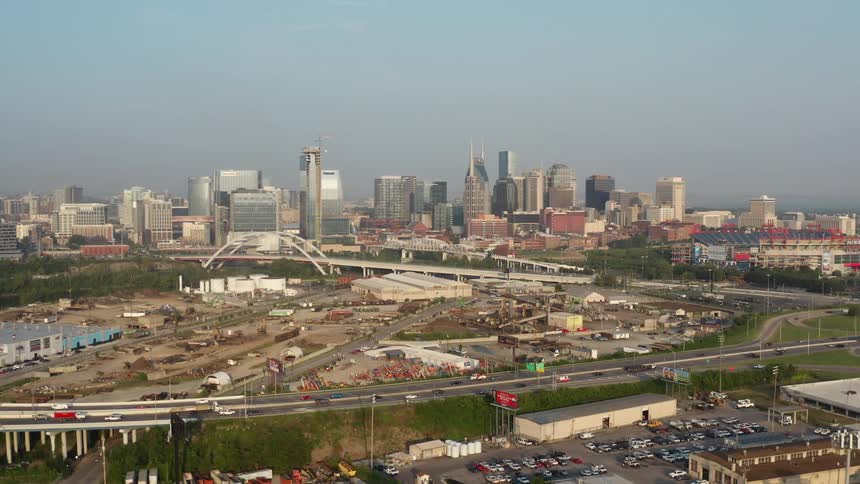 A city skyline with a highway buildings and skyscrapers with the sky and clouds in the background