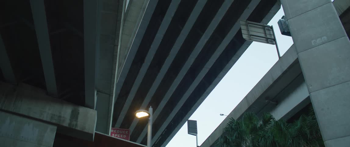 The underside of a cement bridge with signs