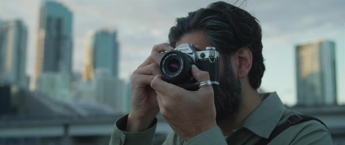 Photographer uses a camera to take pictures of the city at sunset