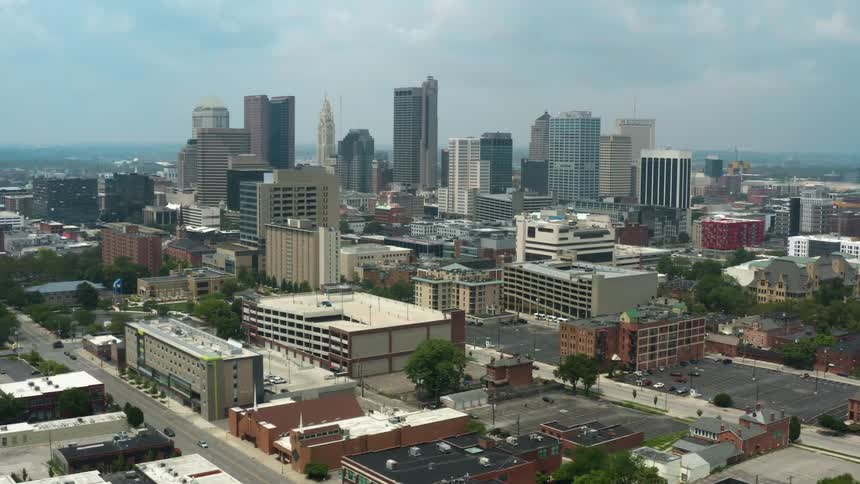 A city skyline with buildings and skyscrapers with the sky and clouds in the background