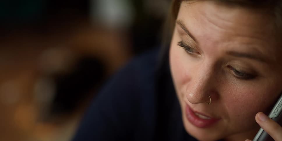 A woman with a nose piercing talking on a phone