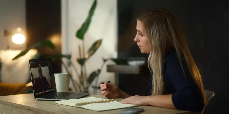A woman is having a video conference at her desk
