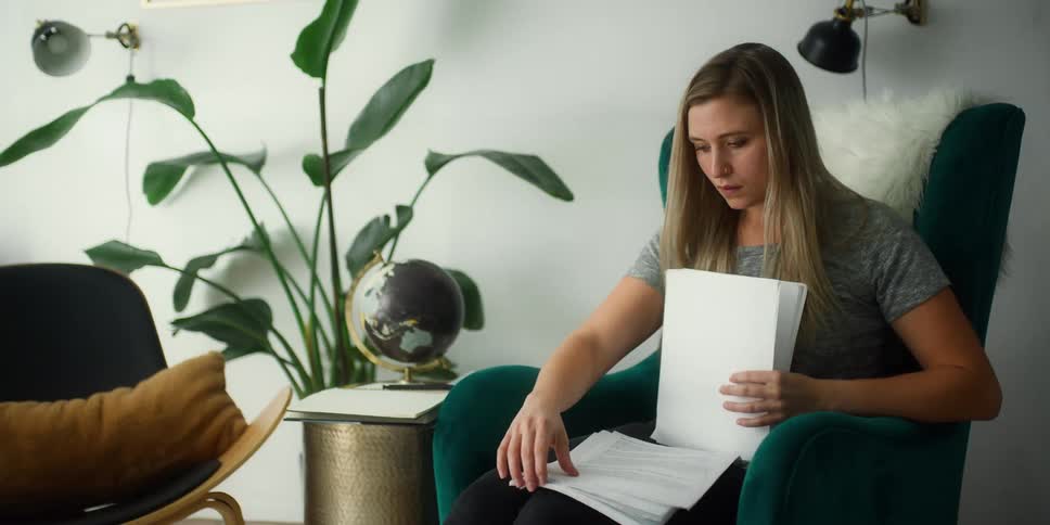 A woman is looking through paperwork