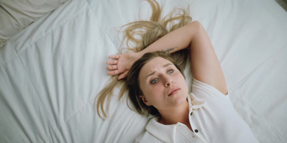A woman is laying in bed awake
