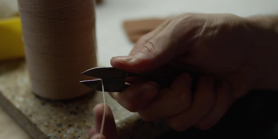 A man clips a thick piece of thread