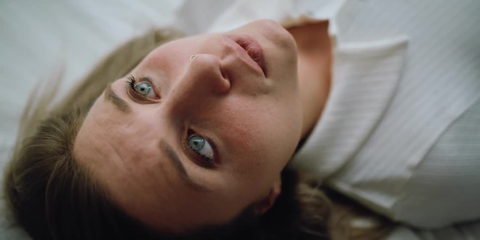 A woman in a room laying on a bed