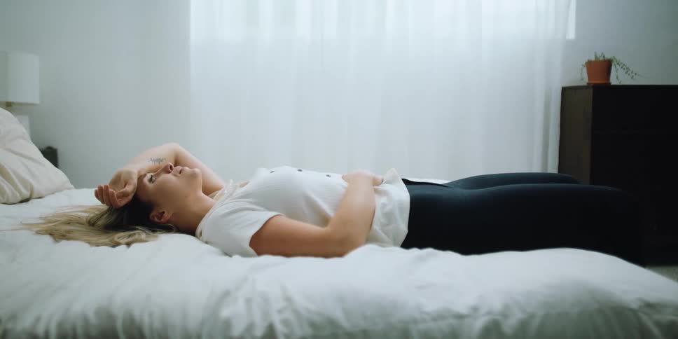 A woman laying in a bed crying