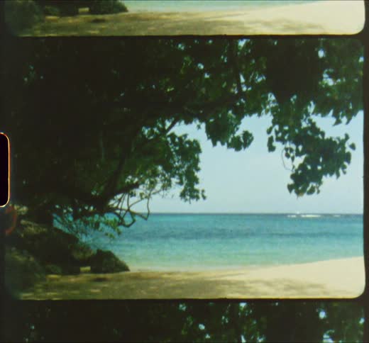 Small blue waves crash against the golden sand beach