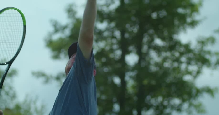 A man hitting a tennis ball with a racket outdoors