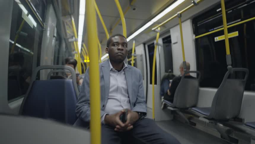 Man with blue blazer jacket and dark pants travels on subway