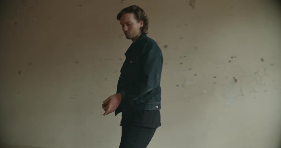 A man measures a window writes it down and then sits on the floor of an empty apartment