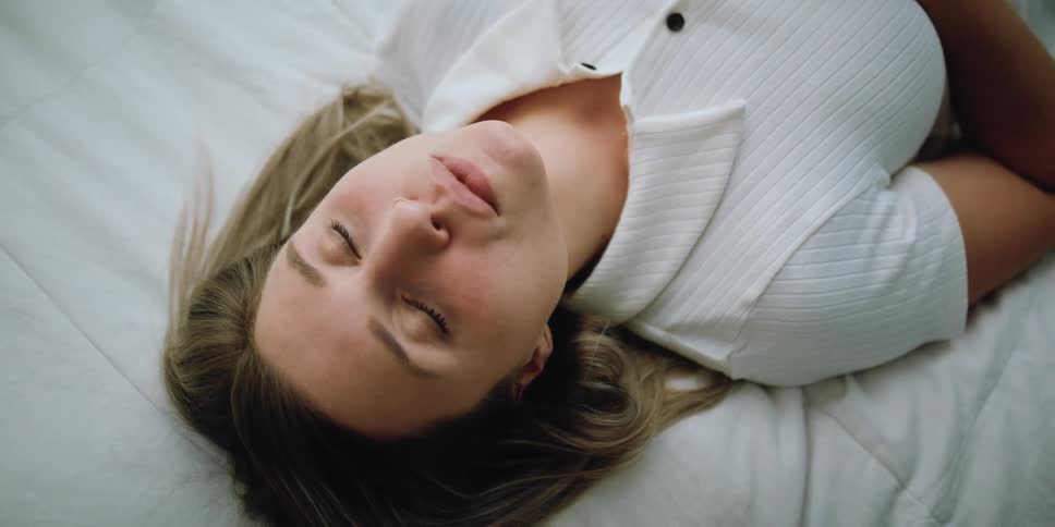 A woman in a room laying on a bed